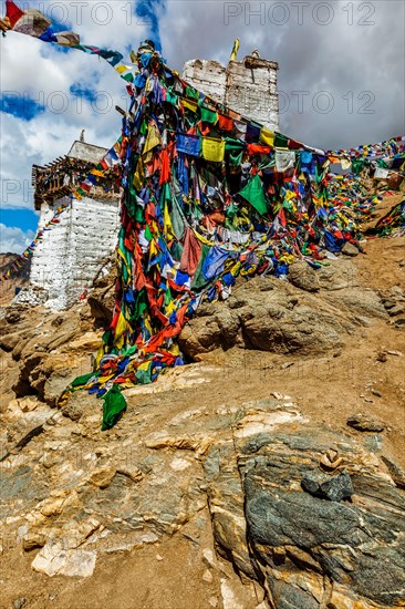 Ruins of Victory Fort Tsemo on the cliff of Namgyal hill and colorful Buddhist prayer flags with Buddhism mantra written on them. Leh