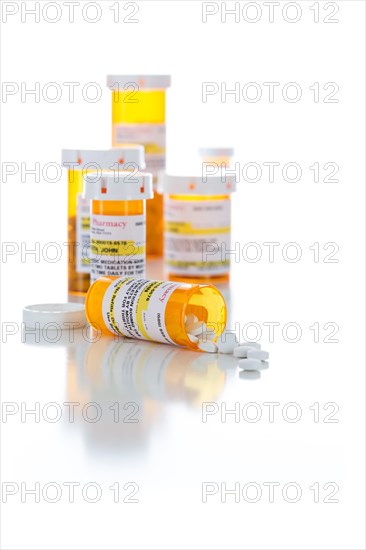 Non-Proprietary medicine prescription bottles and spilled pills isolated on a white background