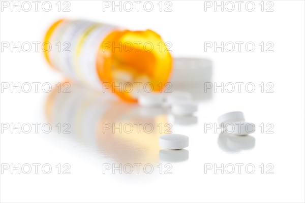 Non-Proprietary medicine prescription bottle and spilled pills isolated on a white background