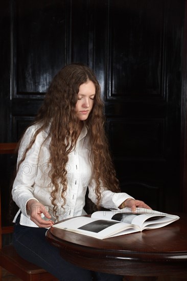 Young beautiful woman with long hairsreading a book