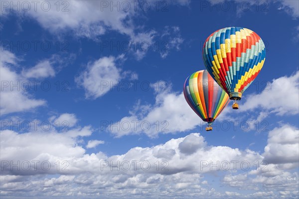 Two hot air balloons up in the beautiful blue sky