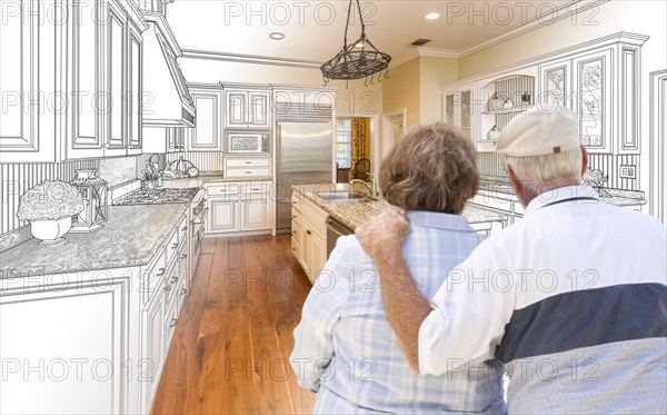 Senior couple looking over custom kitchen design drawing and photo combination