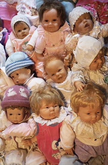 Various decorative dolls and baby dolls lying together