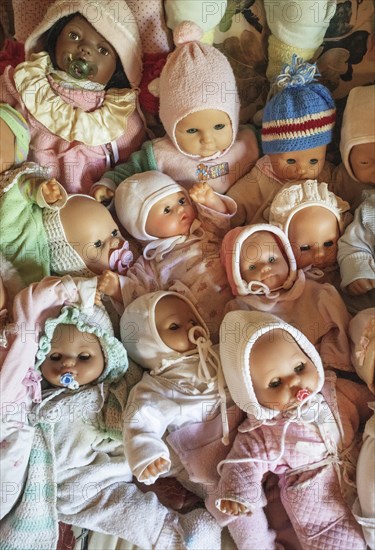 Various decorative dolls and baby dolls lying together