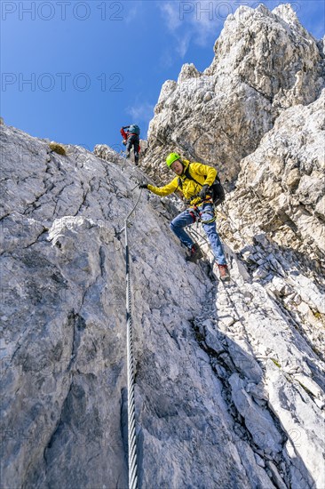 Two climbers on a via ferrata on a steep rock face