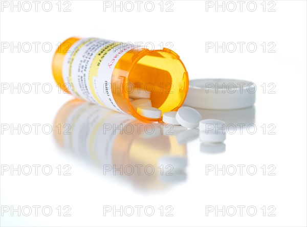 Non-Proprietary medicine prescription bottle and spilled pills isolated on a white background