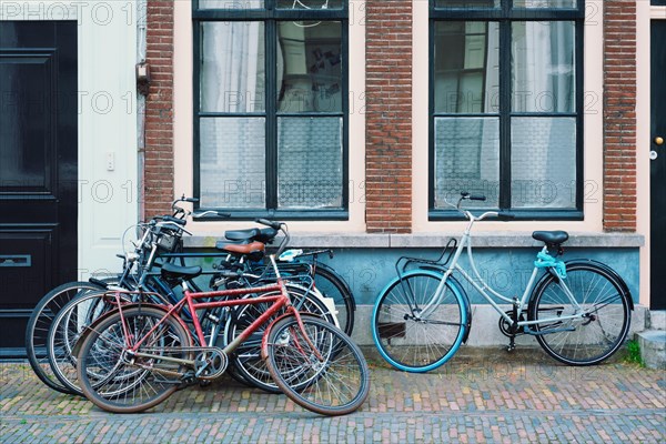 Bicecles which are a very popular transport in Netherlands parked in street near old houses. Utrecht