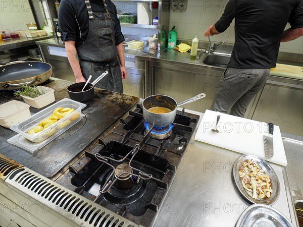 Chef making apotato sauce cream reduction in a professional kitchen of a restaurant