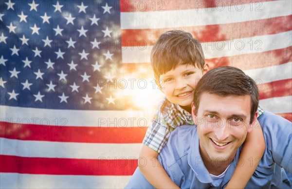 Father with son piggy back riding in front of american flag