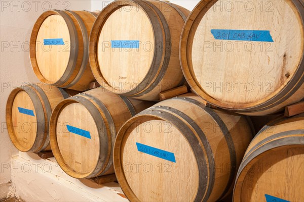 Several various wine barrels age inside cellar