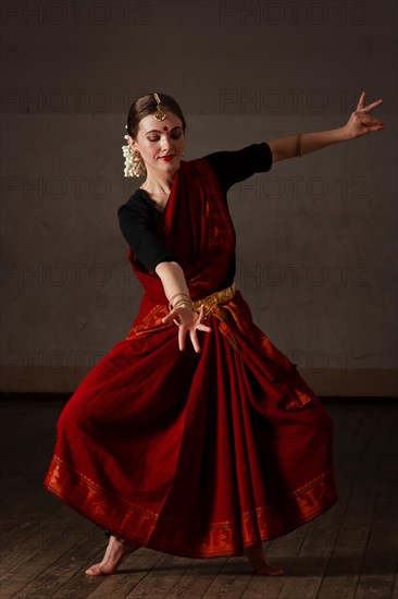 Young woman in sary dancing classical traditional indian dance Bharat Natyam