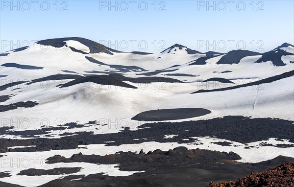 Barren hilly volcanic landscape of snow and lava fields