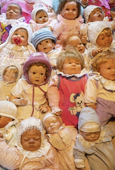 Various decorative dolls and baby dolls lying together