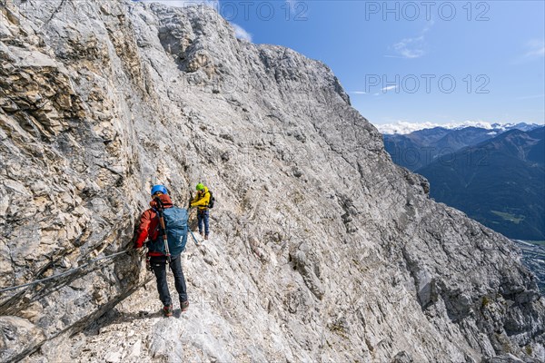 Two climbers on a via ferrata on a steep rock face