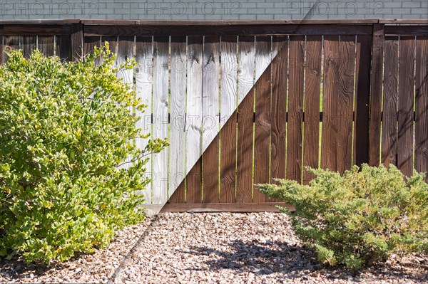 Yard fence before and after solid paint stain application