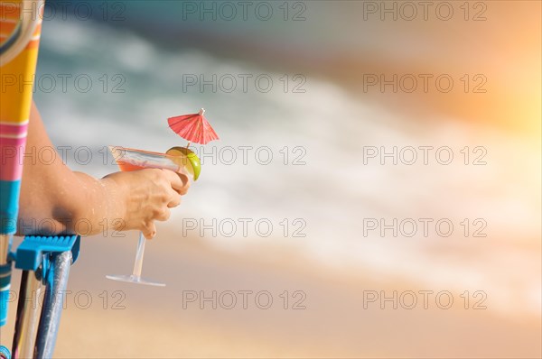 Woman relaxing on beach with tropical drink