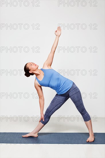 Beautiful sporty fit woman practices yoga asana utthita trikonasana