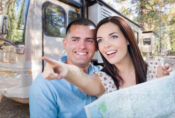 Young military couple looking at map in front of RV