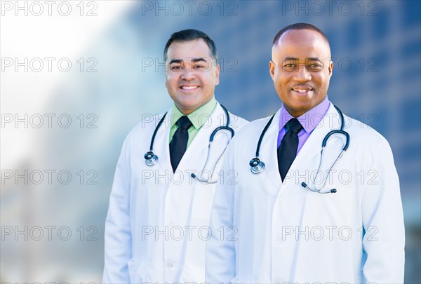 Handsome african american and hispanic male doctors outside of hospital building