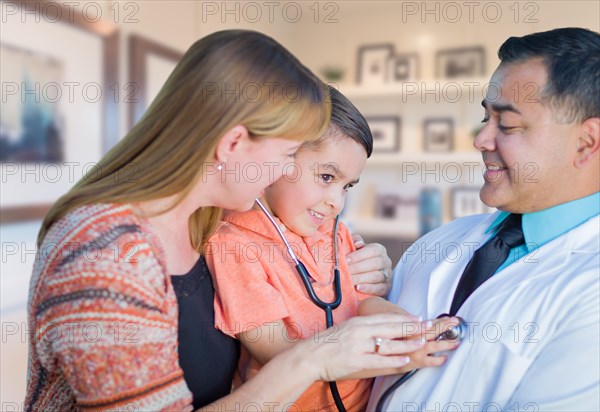 Young boy and mother visiting with hispanic doctor in office