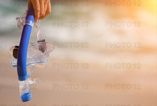 Woman holding snorkeling gear on the shoreline