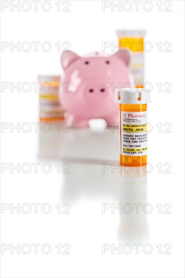 Piggy bank and non-proprietary medicine prescription bottles isolated on a white background