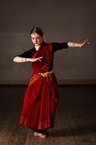 Young woman in sary dancing classical traditional indian dance Bharat Natyam