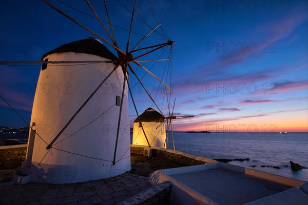 Scenic view of famous Mykonos Chora town windmills. Traditional greek windmills on Mykonos island illuminated in the evening