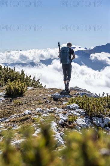 Hiker looking over low clouds