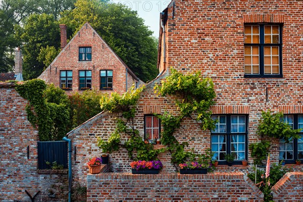 Old houses of Begijnhof Beguinage with flowers in Bruges town
