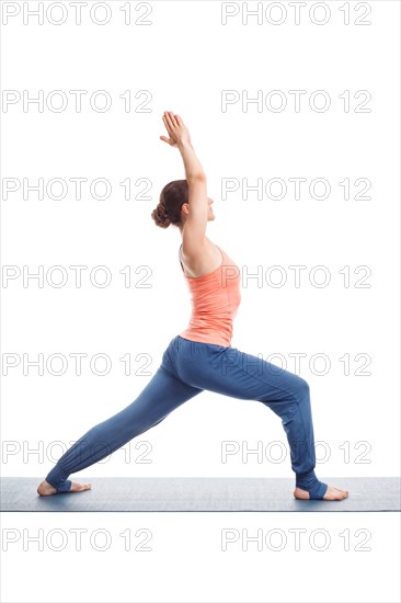 Beautiful sporty fit yogini woman practices yoga asana Virabhadrasana 1