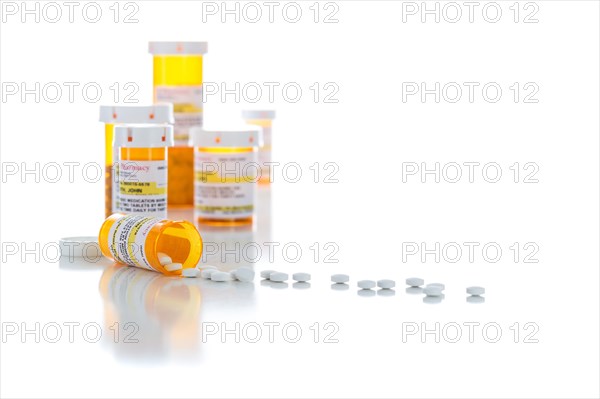 Non-Proprietary medicine prescription bottles and spilled pills isolated on a white background