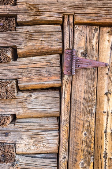 Abstract of vintage antique log cabin wall and door with hinge