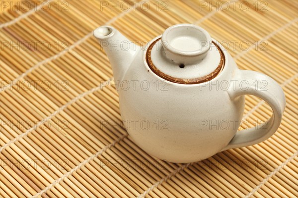 Chinese teapot on bamboo mat close up photo
