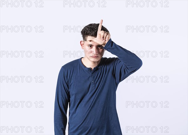 Unhappy man holding hand near forehead showing loser gesture with fingers