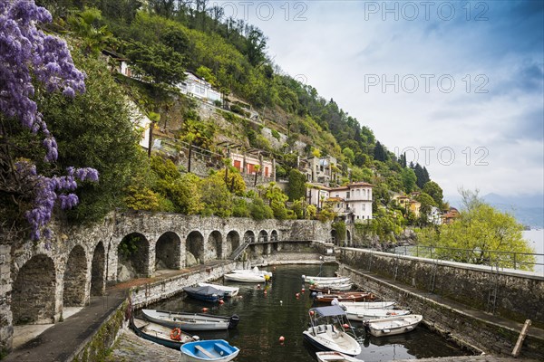 Small boat harbour and colourful villas on the lakeside