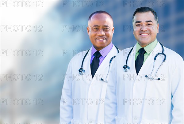 Handsome african american and hispanic male doctors outside of hospital building