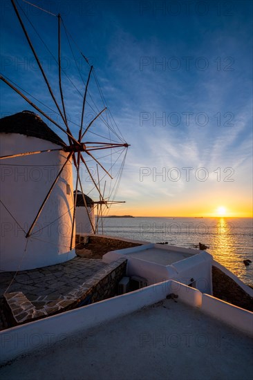 Scenic view of famous Mykonos Chora town windmills. Traditional greek windmills on Mykonos island illuminated in the evening