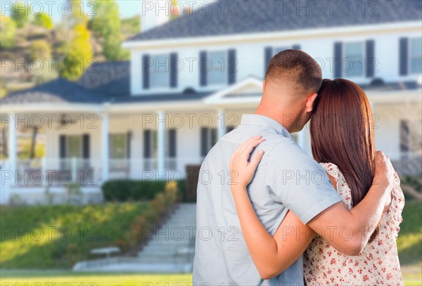 Affectionate military couple looking at beautiful new house