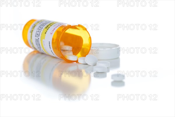 Non-Proprietary medicine prescription bottle and spilled pills isolated on a white background