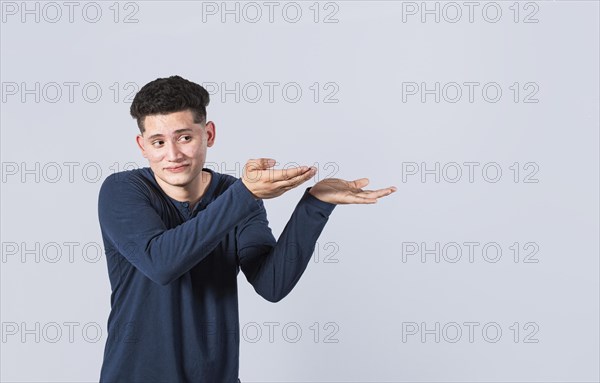 Handsome man pointing palms to the side