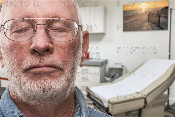Worried senior adult man waiting in doctor office