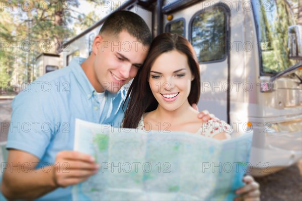 Young military couple looking at map in front of RV