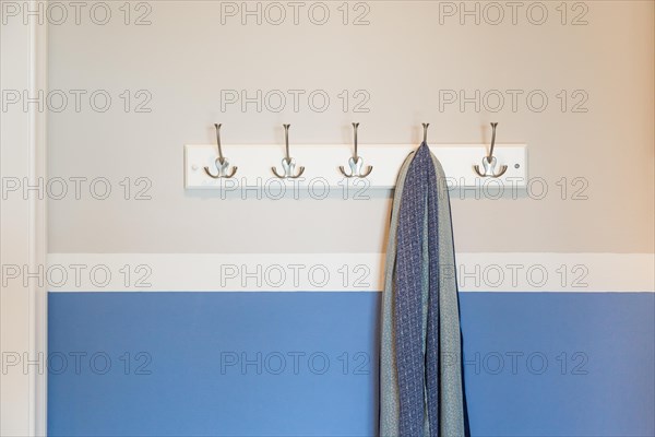 Wall in house with scarf hanging on coat rack hooks abstract