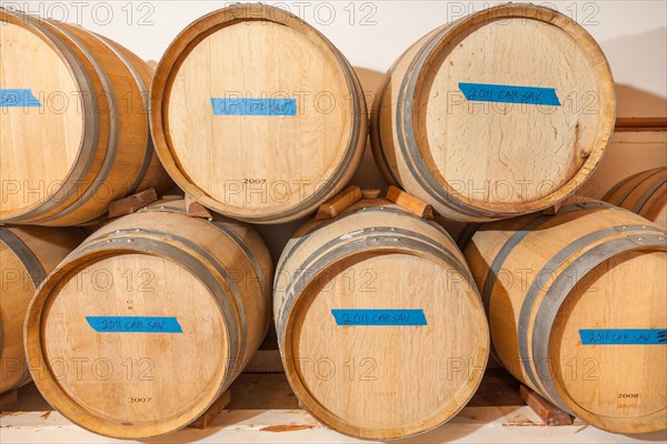 Several various wine barrels age inside cellar