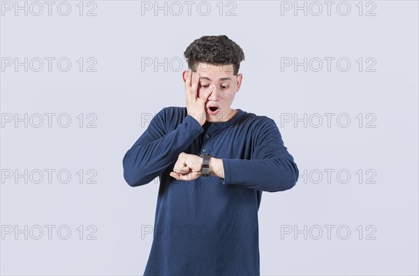 Young man looking at the watch time worried