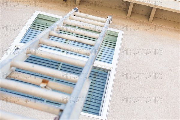 Aluminum construction ladder leaning against house