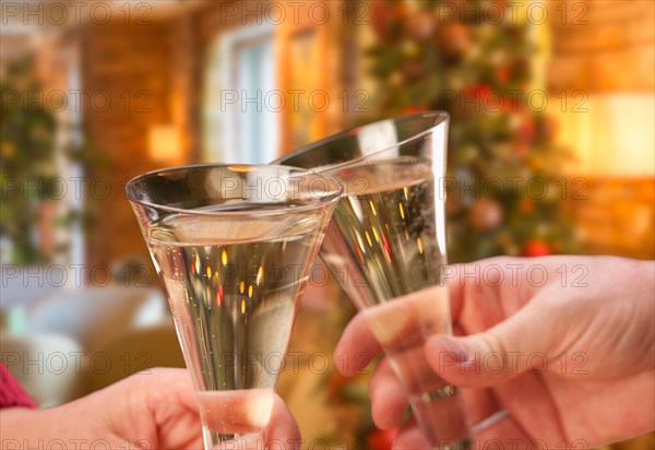 Man and woman toasting champagne in front of decor and lights