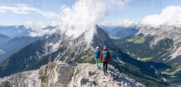 Hiker with climbing helmet on a steep rocky ridge