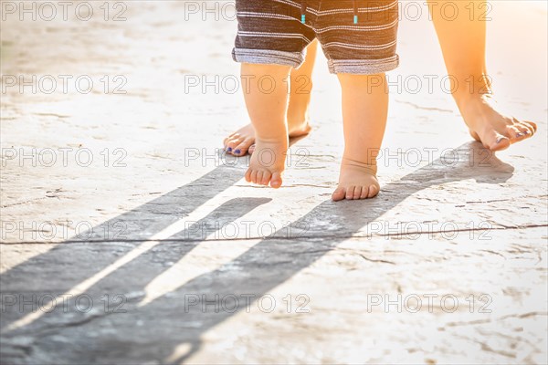 Mother and baby feet taking steps outdoors